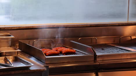 meat cooking on a stainless steel grill with smoke
