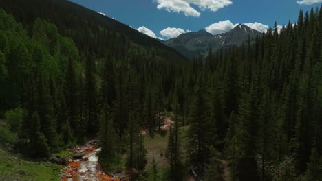 Aerial-cinematic-drone-orange-river-Cement-Creek-summer-high-altitude-downtown-Silverton-Telluride-Prospect-Gulch-Colorado-Rocky-Mountains-stunning-drive-looking-up-steam-backward-movement