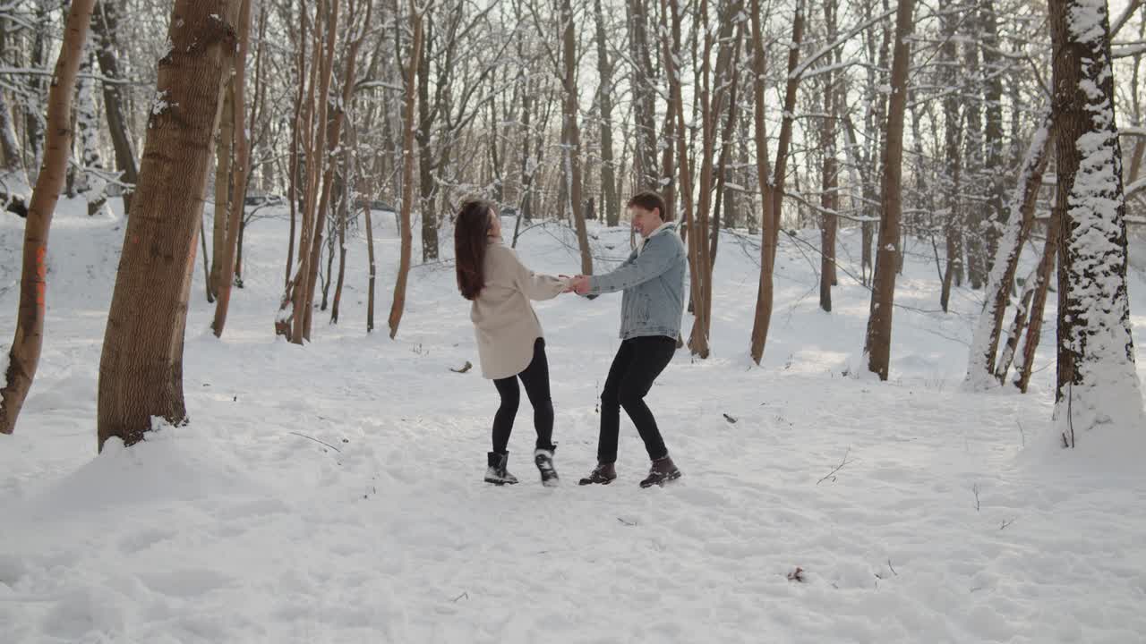 행복한 젊은 아름다운 부부는 함께 이 많은 겨울의 숲에서 즐겁게 지내고 있습니다.