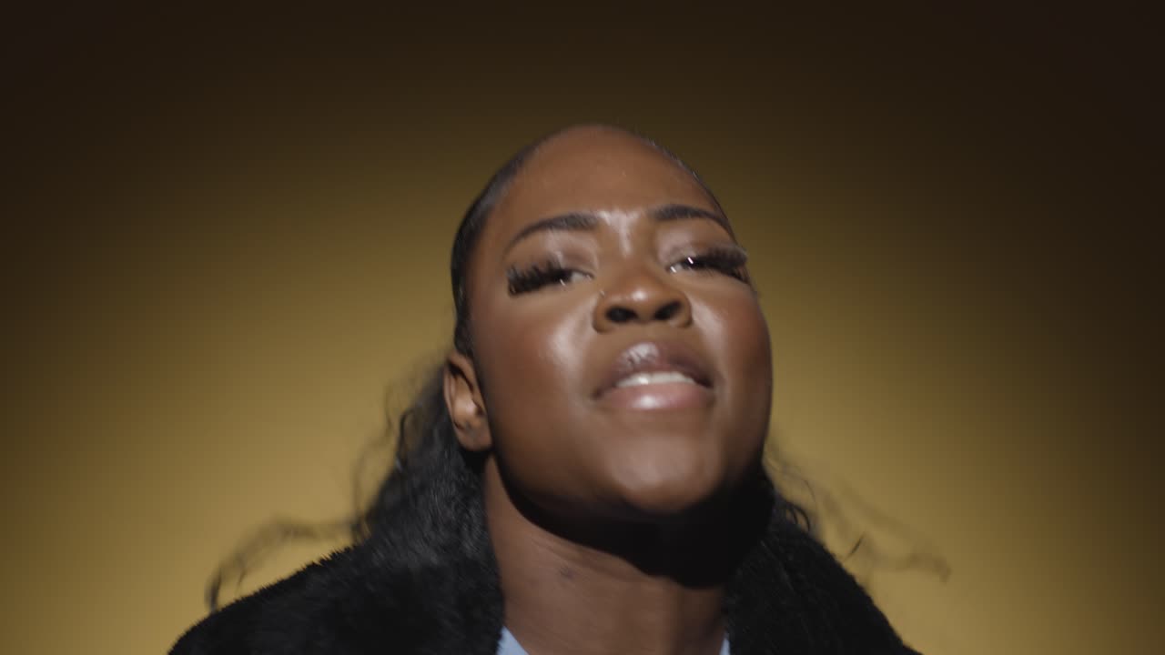 cabeza y hombros estudio retrato de una mujer joven bailando en el centro de atención contra un fondo amarillo 1