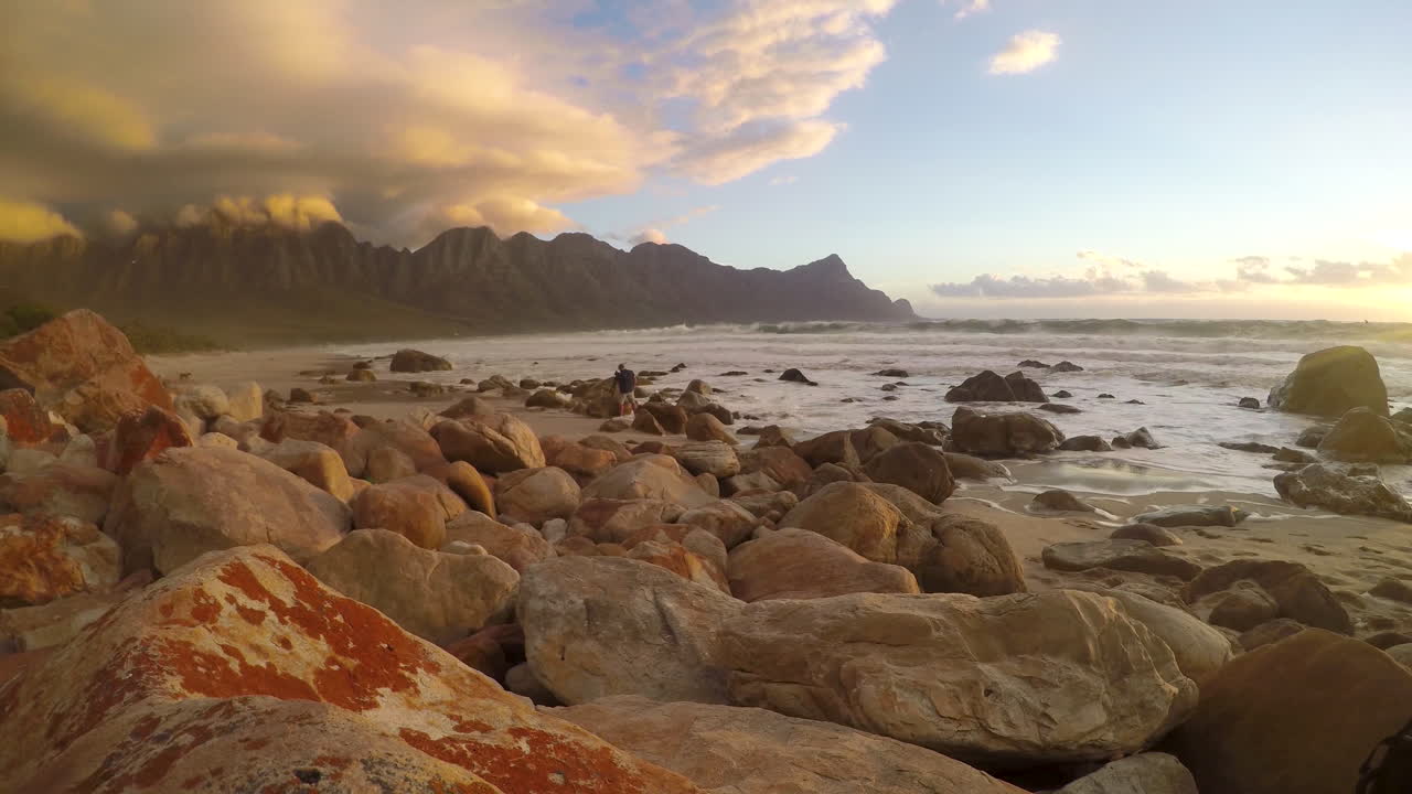un breve lapso de tiempo de las olas rompiendo sobre una playa rocosa mientras el fotógrafo toma fotografías