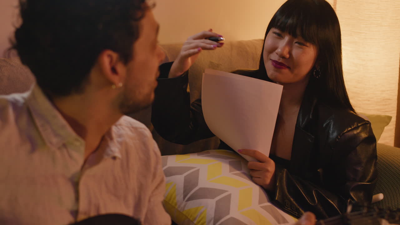 부부 가 노래 하고 기타 를 연주 하고 있다