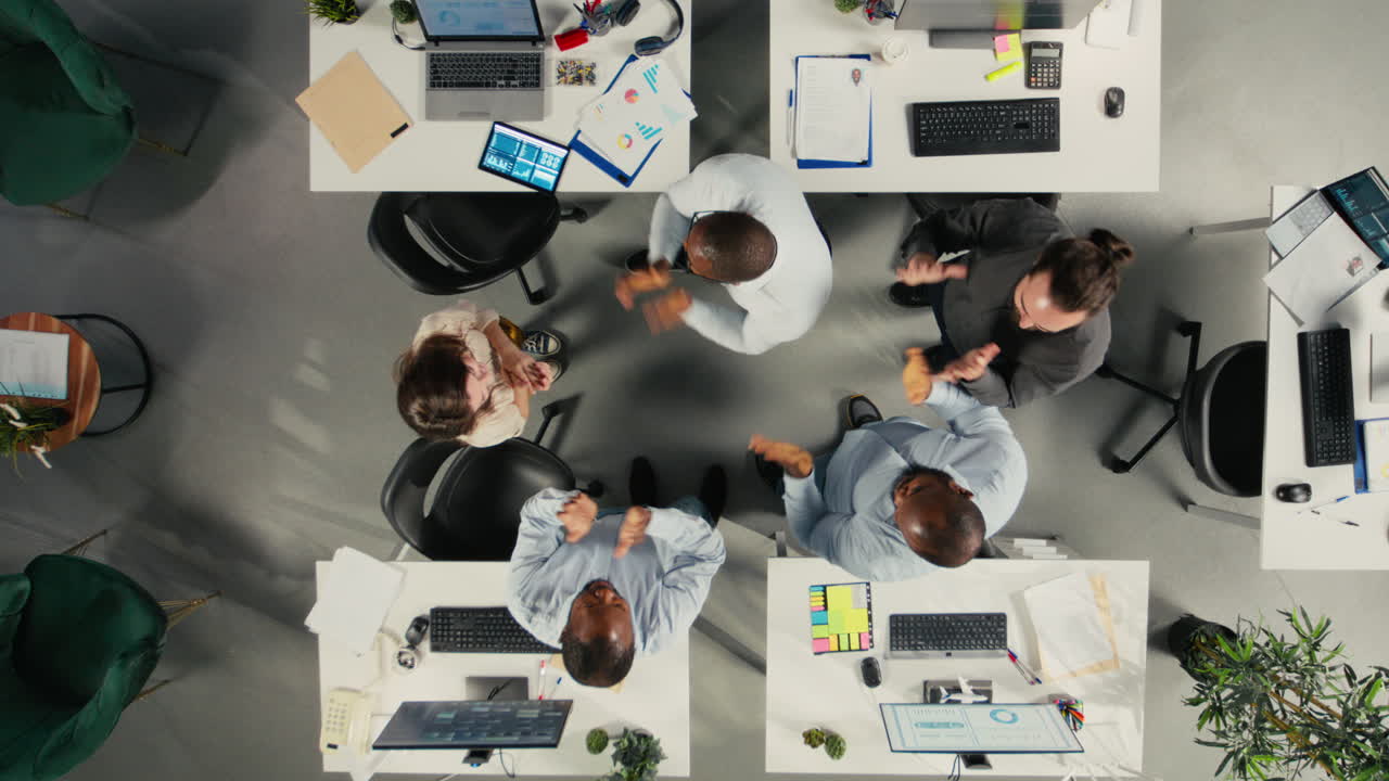 Vertical Video Top down view zoom out of company employees uniting hands and cheering