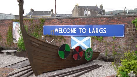 cartel de bienvenida al pueblo de largs que representa un medio barco vikingo
