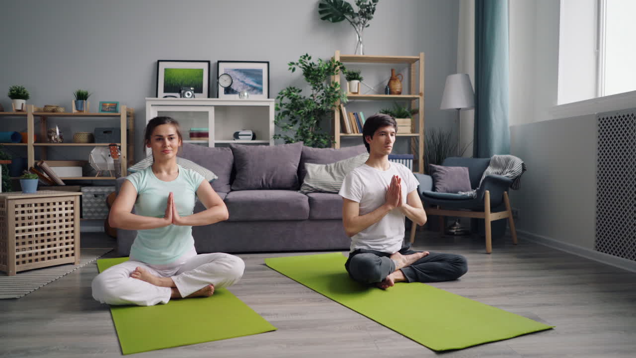 pareja practicando yoga en casa