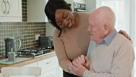 caregiver assisting elderly man in kitchen