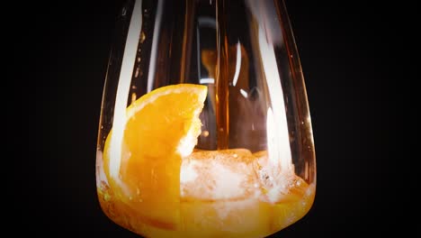 orange slice in glass with ice and liquid