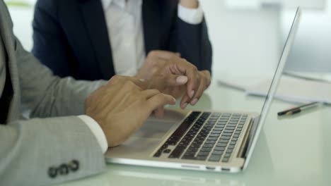 fotografía en primer plano de manos masculinas escribiendo en una computadora portátil