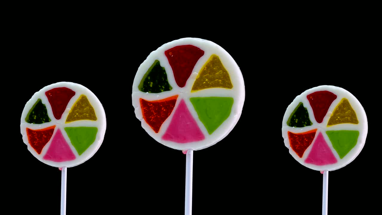 fondo de piruleta multicolor sobre un fondo negro. piruleta de caramelo. dulces para niños