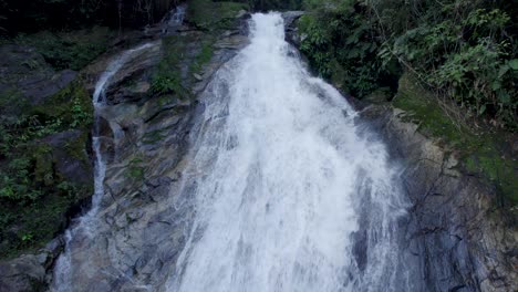 drone near a waterfall, moving up revealing it