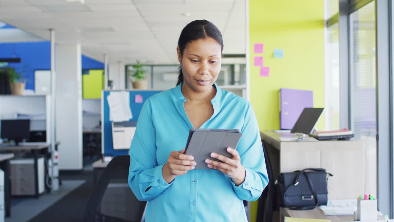 Portrait of african american businesswoman using tablet at office, slow motion