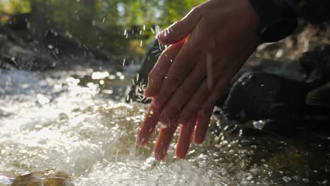 primer plano de cámara lenta de una persona que se lava las manos en un río