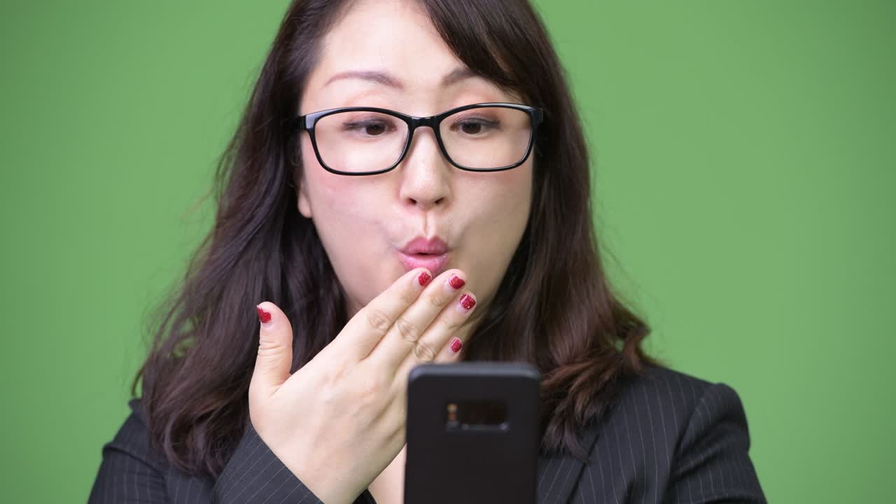 성숙 한 아름다운 아시아 사업가 여자 는 전화 를 사용 하는 동안 충격 을 느끼고 있다