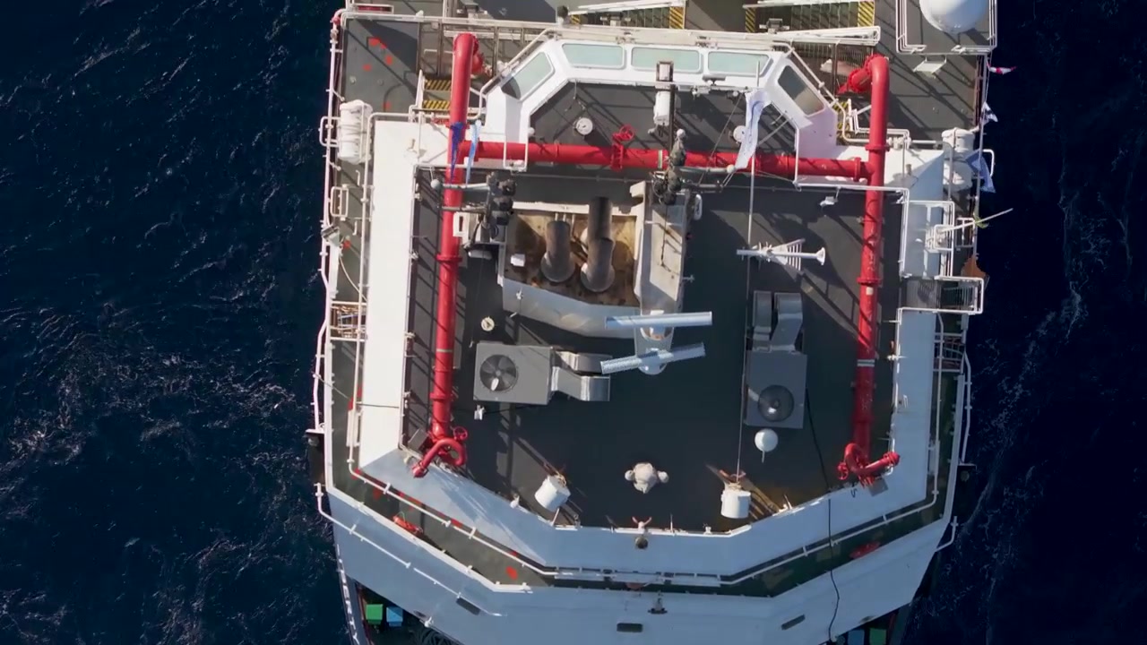 Vertical drone perspective of an offshore service boat deck showcasing technical equipment, rescue craft, and specialized industrial infrastructure on open water
