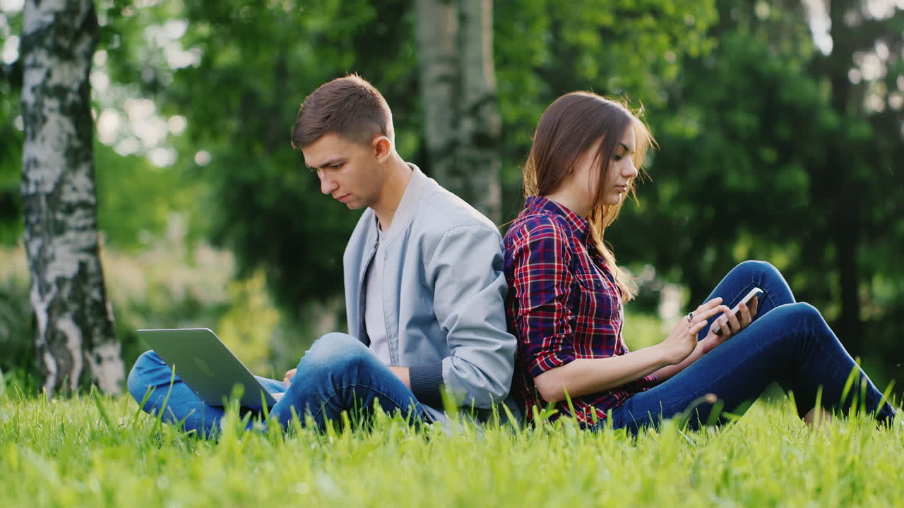 los jóvenes descansan en la naturaleza un hombre usa una chica portátil haciendo selfie smartphone hd video