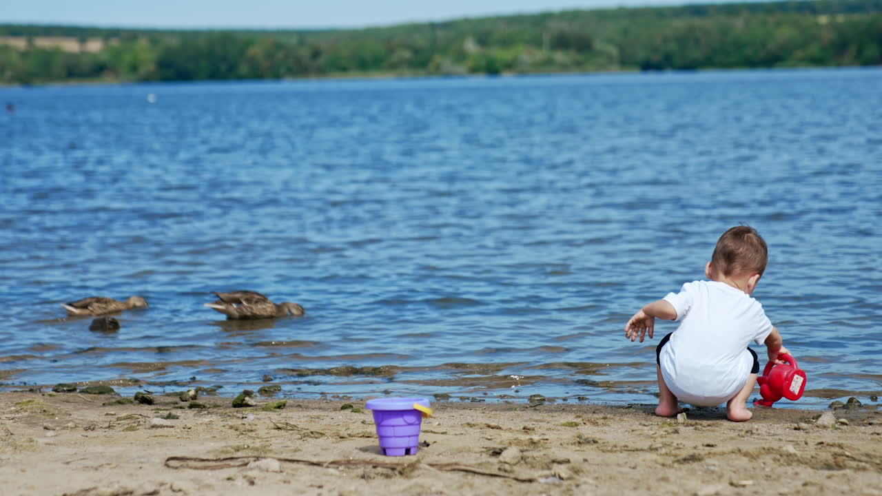 Child playing on the beach near a lake