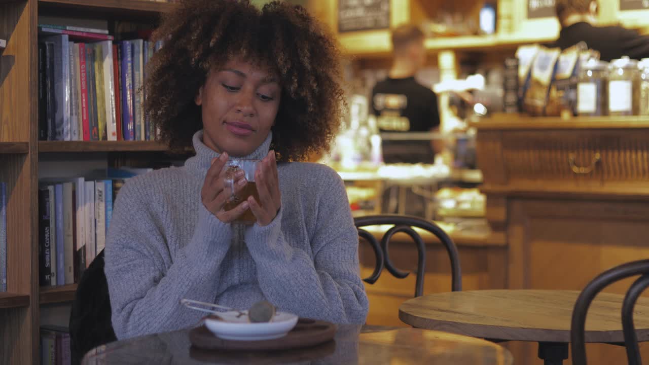 Kvinde nyder en kop te på en café