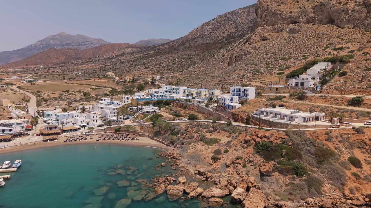 Panoramic aerial view of Finiki village in Karpathos, showing the traditional port, white houses, and mountains surrounding the scenic coastal landscape