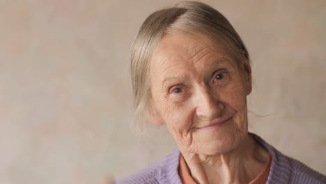 Close-up-portrait-of-a-happy-elderly-senior-woman-looking-at-camera-and-smiling