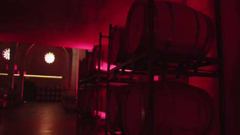 amazing shot of a beautiful container of wine with neon red color of barrels inside a wine factory in burgos, spain in 4k