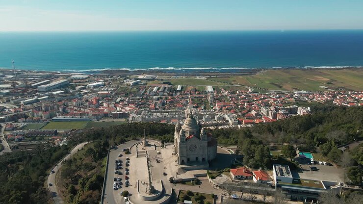 Aerial: Santa Luzia's embrace over Viana, where land meets azure sea