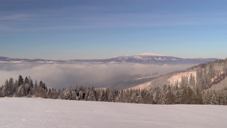 Hermosa-Vista-Sobre-El-Paisaje-Invernal-Con-árboles,-Inversión-De-Nubes-En-La-Distancia-Y-La-Montaña