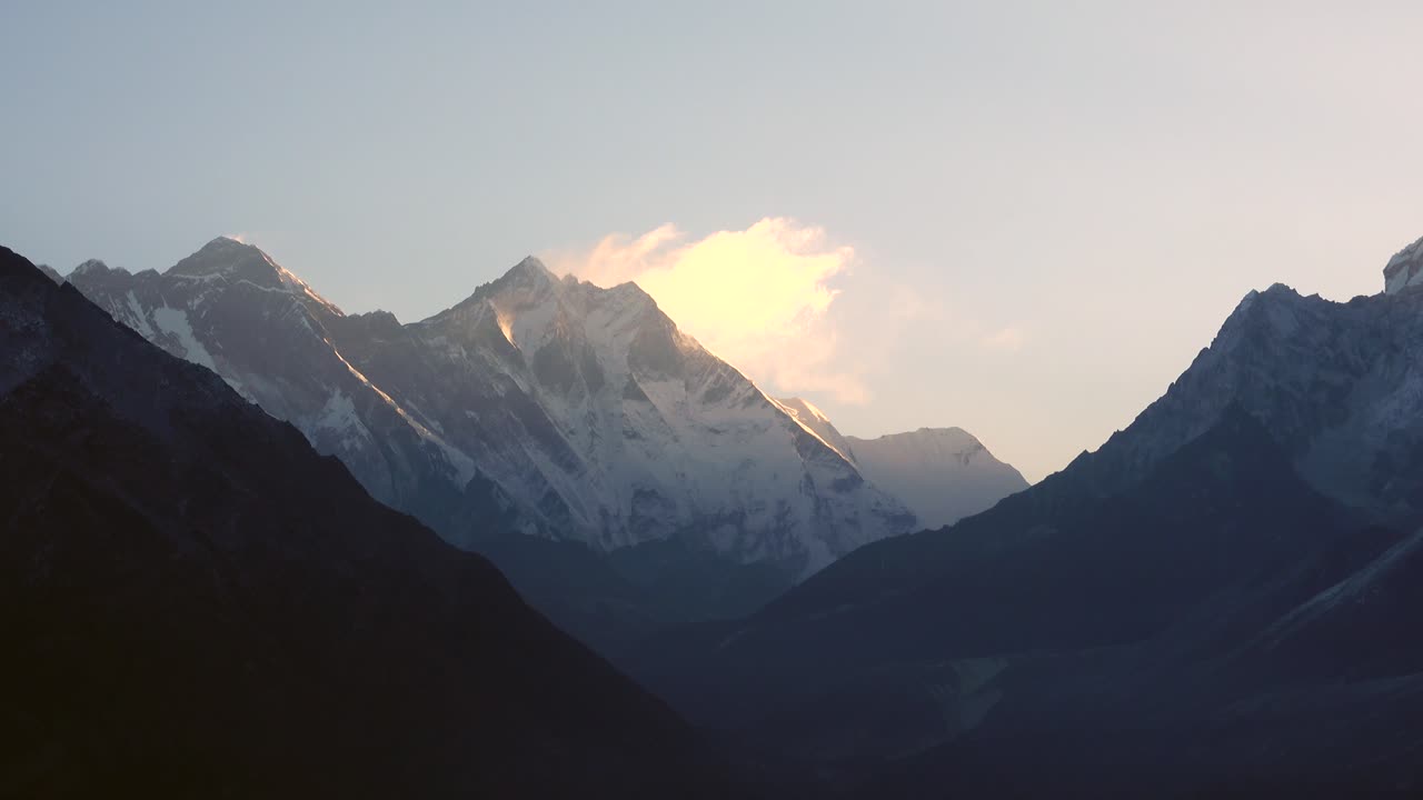 A view of the majestic Himalaya Mountains in the early morning light with a slight fog and haze in the foreground