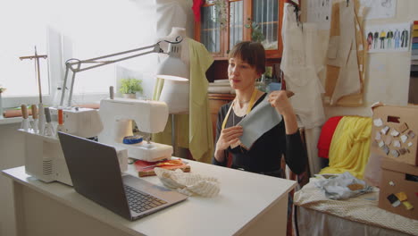 Woman-Discussing-Fabric-on-Web-Call-in-Sewing-Studio