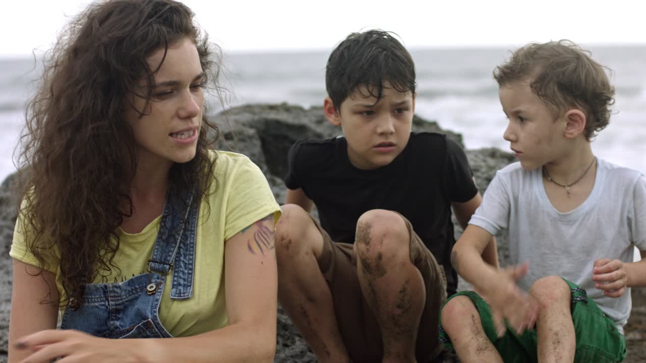 madre joven hablando con dos hijos