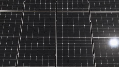 aerial view above reflecting photovoltaic solar panels on a house roof, sunny day