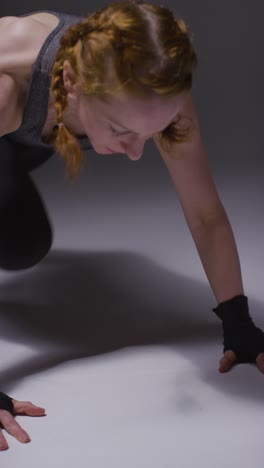 Vertical-Video-Studio-Shot-Of-Mature-Woman-Wearing-Gym-Fitness-Clothing-Doing-Mountain-Climber-Exercise-2