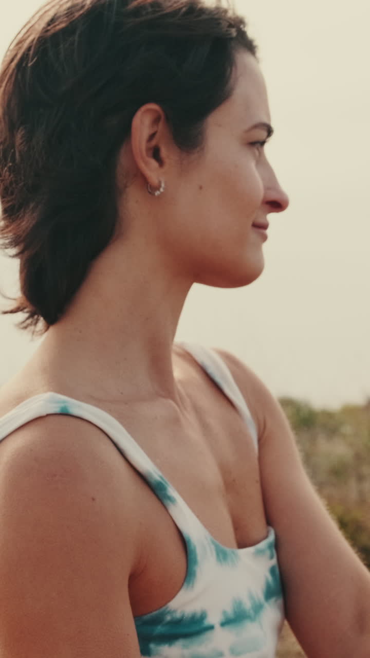 Giovane donna che fa stretching all'aperto in un tranquillo paesaggio costiero