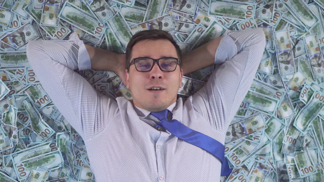 Portrét spokojeného podnikatele v obleku ležícího na bankovkách, detail