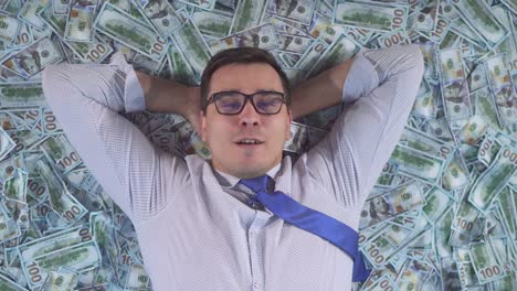 retrato de un hombre de negocios satisfecho con ropa de negocios acostado en billetes de banco de cerca
