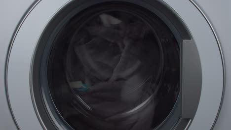 Ladung-Dunkler-Handtuchkleidung,-Die-Sich-In-Zeitlupe-In-Der-Waschmaschine-Dreht