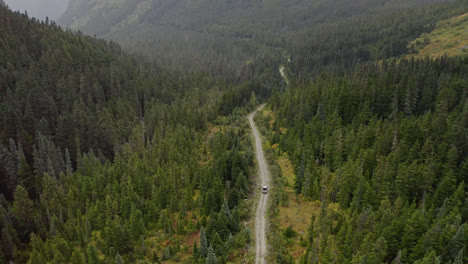 Breite-Luftaufnahme-Des-Geländewagens,-Der-Bergwaldstraße-In-Britisch-Kolumbien-Fährt