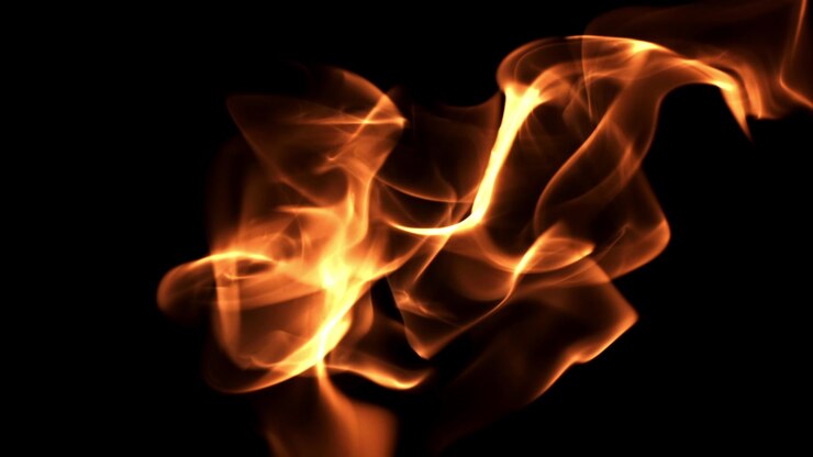 Fiamme dorate che bruciano su sfondo nero al rallentatore