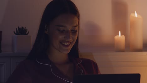 mujer leyendo en la computadora portátil por la noche