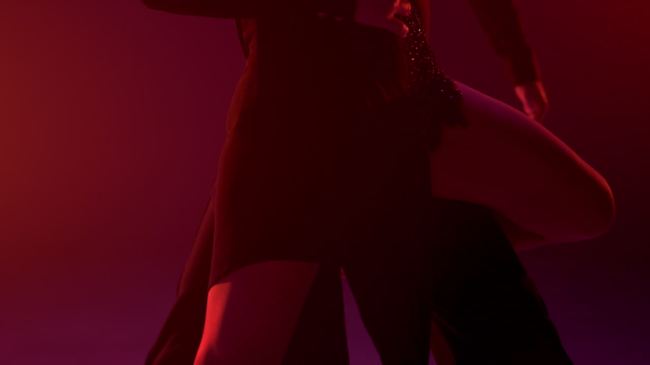 Unrecognizable woman lifting leg dance partners inside. Ballroom couple dancing