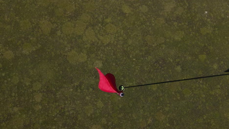 Vista-Superior-De-La-Bandera-Roja-Del-Poste-De-Golf-En-Verde-Bien-Cuidado-En-El-Campo-De-Golf-En-Australia