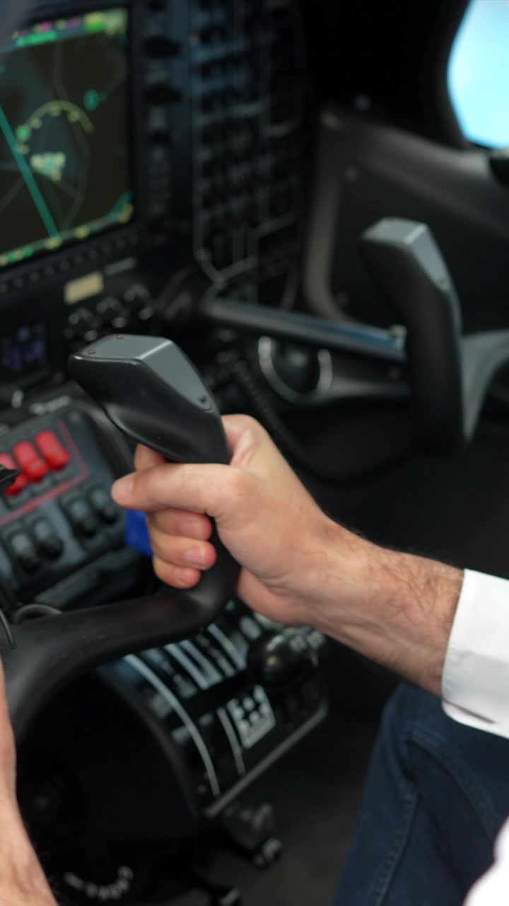 Pilota che aziona i comandi di volo in una moderna cabina di pilotaggio di un aereo