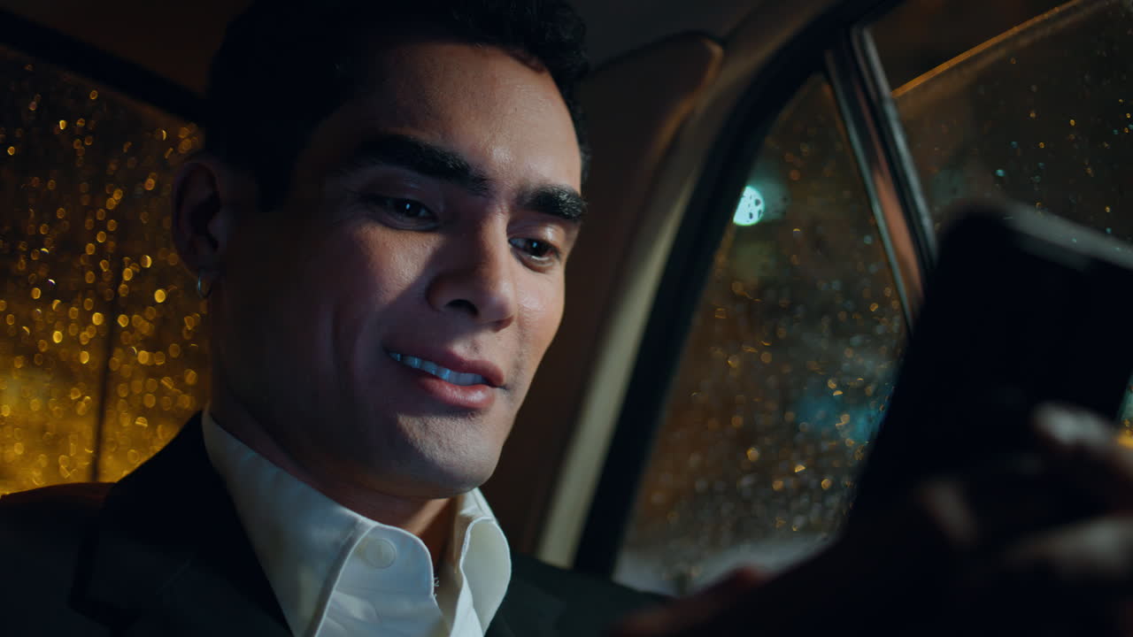 근접 웃는 직원이 차량에서 전화를 보내고 스마트폰을 읽는 남자