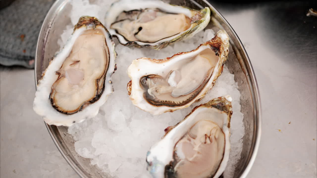 Close up of a bucket with raw oyster on ice at a restaurant