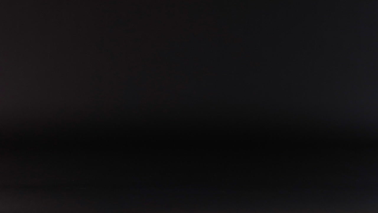 una pelota rosa rebota contra un fondo oscuro