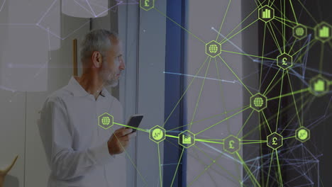 globo de iconos digitales contra un empresario caucásico que usa un teléfono inteligente en la oficina