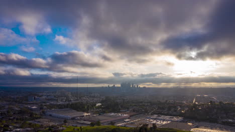 Hiperlapso-De-Drones-Durante-La-Puesta-De-Sol-Sobre-Un-Suburbio-De-Los-ángeles-Con-La-Silueta-Del-Horizonte-Del-Centro-En-La-Distancia