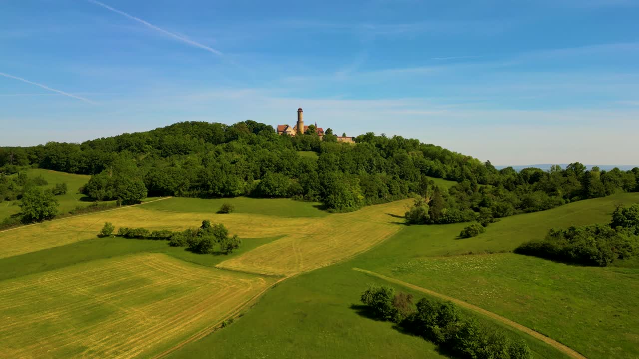 Vídeo aéreo de drone 4K da área agrícola que rodeia o histórico Castelo de Bamberg nos arredores de Bamberg, Alemanha, num belo dia de primavera
