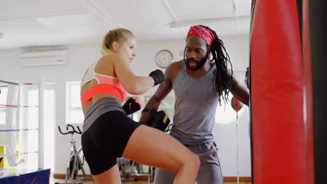 Trainer-training-female-boxer-in-fitness-studio-4k