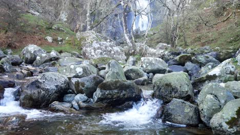 rocky mountain cascading waterfalls flowing into jagged river rocks and boulders wilderness