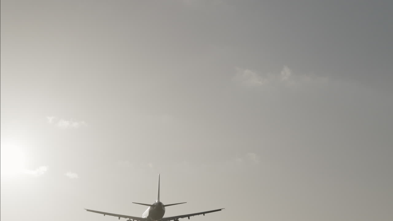 공항에 착륙하기 위해 석양 아래에서 매우 느린 속도로 머리 위를 날아가는 비행기